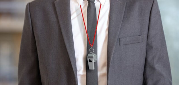 Businessman in a suit wearing a whistle around his neck - whistleblower